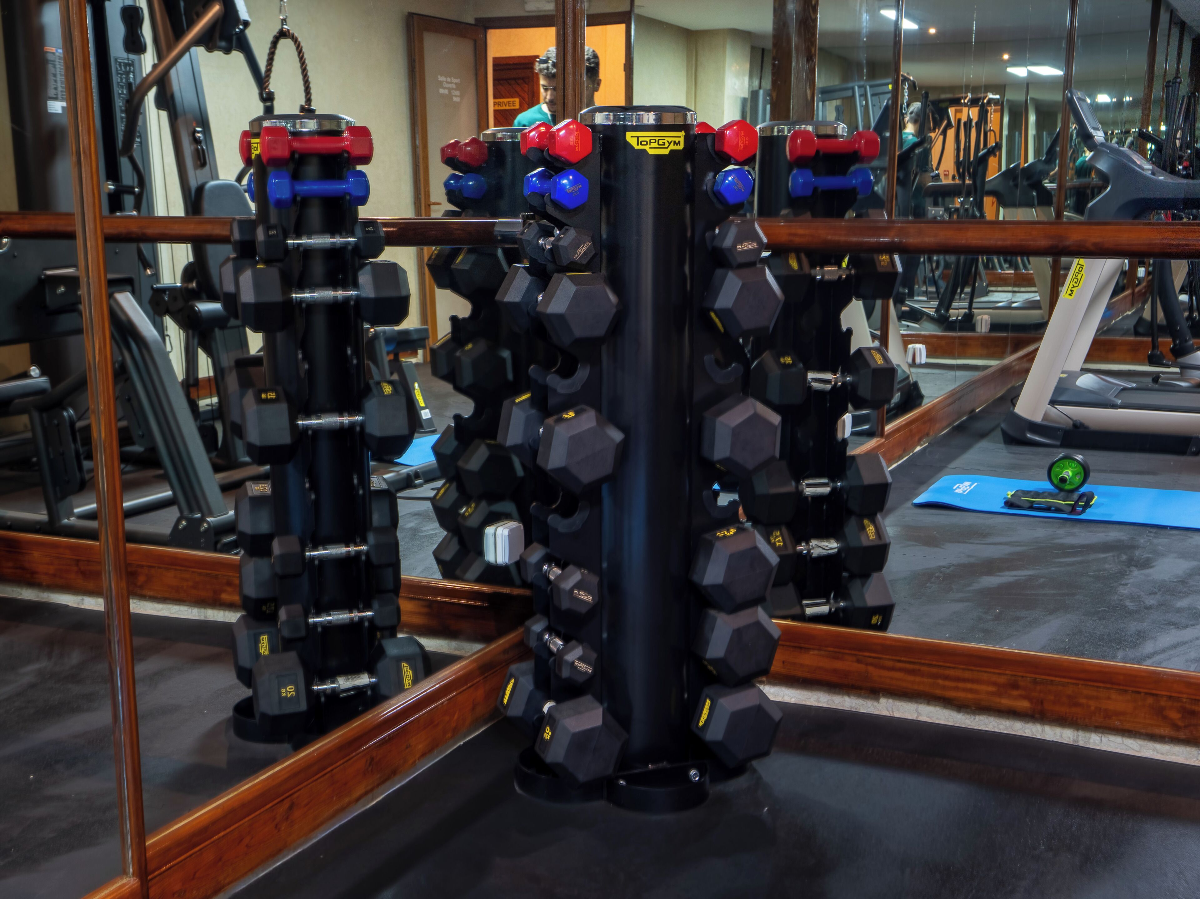 A gym with weightlifting equipment, a mirror, and exercise machines.