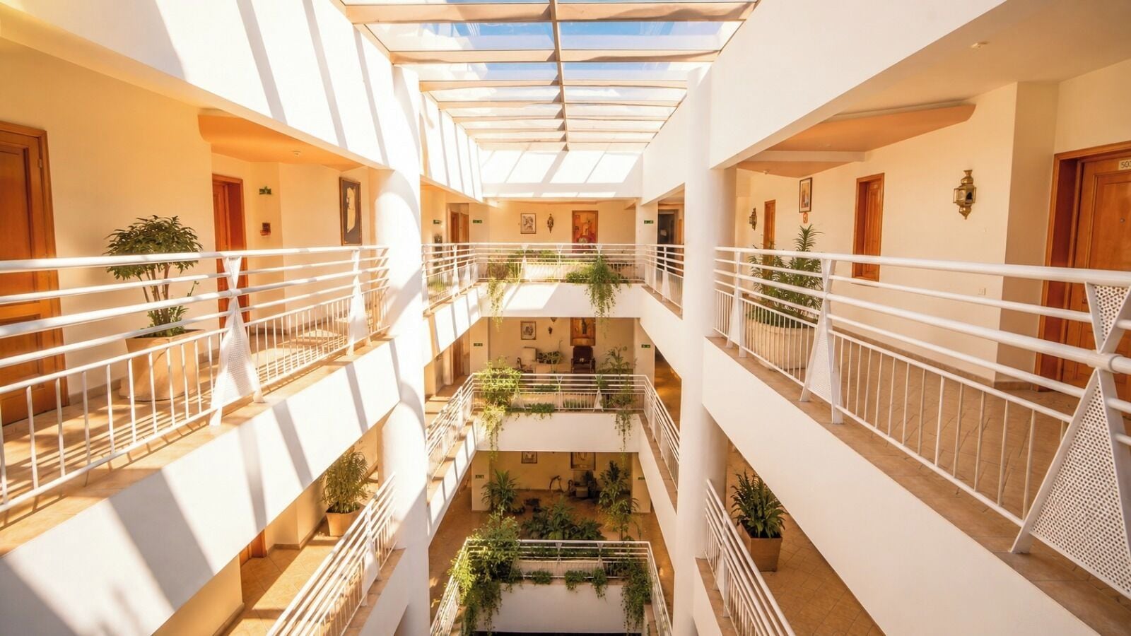 A multi-level atrium with balconies, potted plants, and a central open space.
