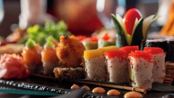Variedad de platos de sushi sobre una bandeja negra.