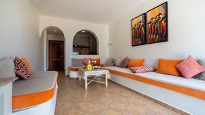 Uma sala de estar com um sofá, uma mesa de centro e um quadro na parede.