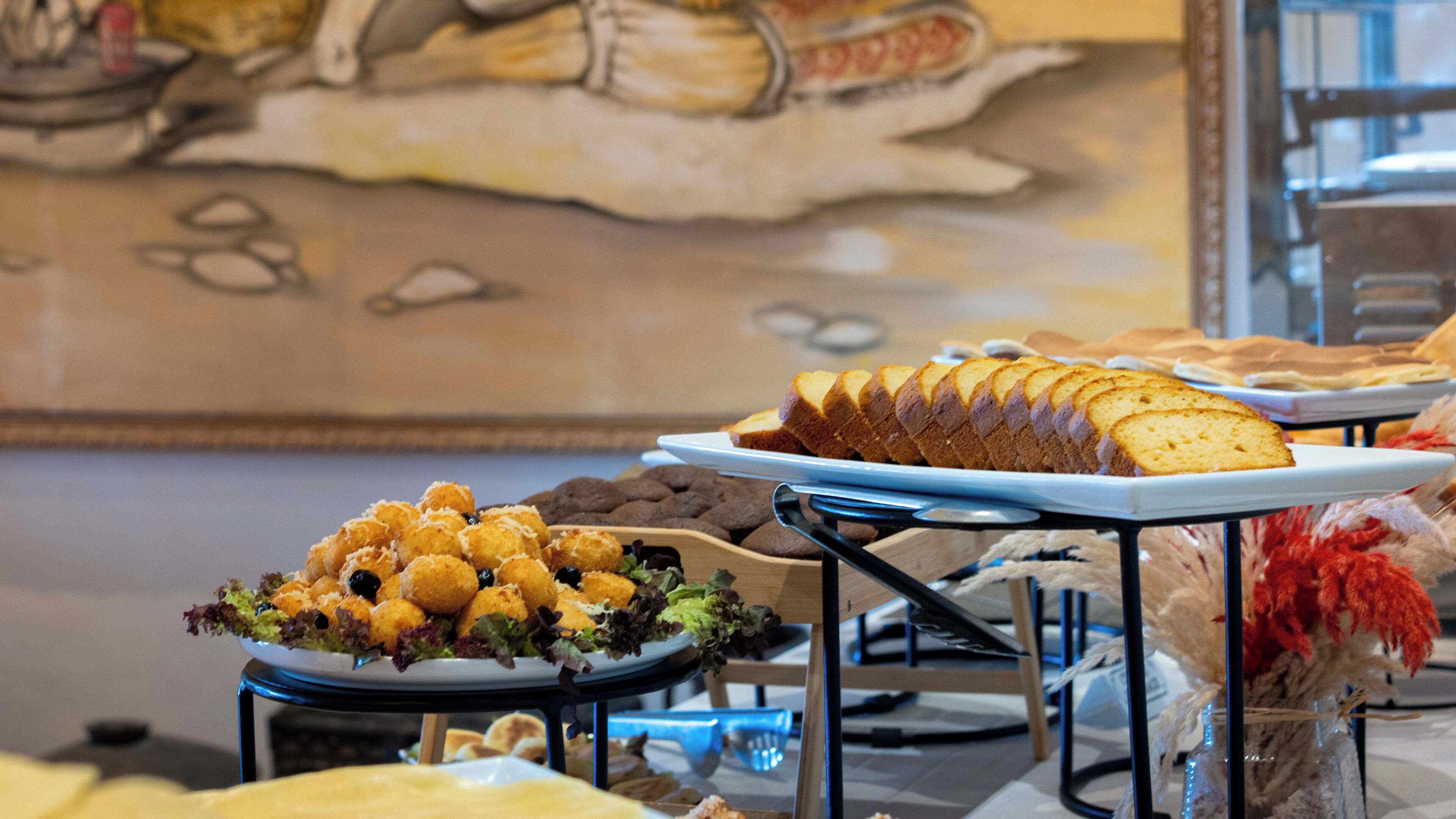 A buffet table with various food items, including bread and salad.