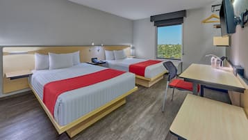 A hotel room with two beds, a desk, a chair, a TV, and a window with a view.
