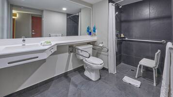 Un baño moderno con un lavabo, inodoro y ducha blancos.