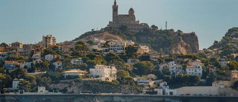 A coastal town with a prominent church on a hill, surrounded by residential buildings.