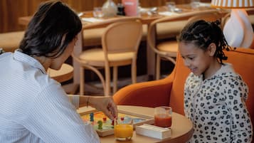 Un comedor con una mesa redonda, sillas y una lámpara.