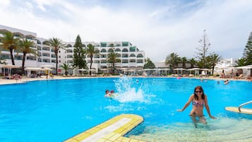 Relax by the pool surrounded by sun loungers and umbrellas, with accommodation facilities nearby.
