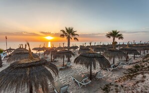 Aan een privéstrand, ligstoelen, parasols, strandlakens