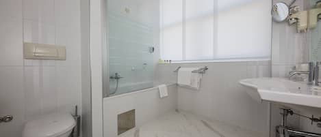 Een moderne badkamer met toilet, douche en wastafel.