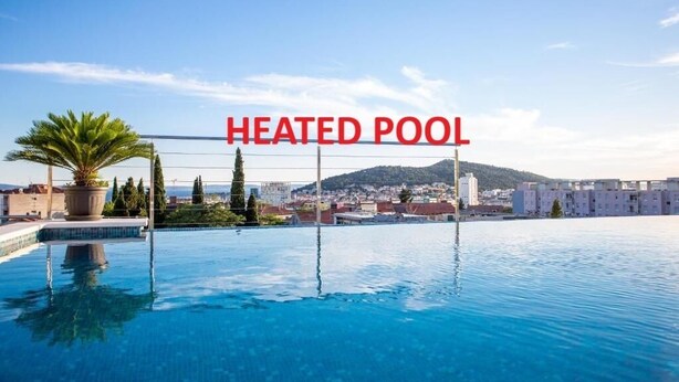 A heated pool with a cityscape view in the background.