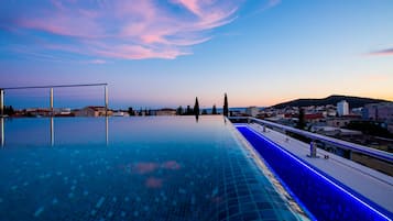 Una piscina al aire libre de temporada, sombrillas