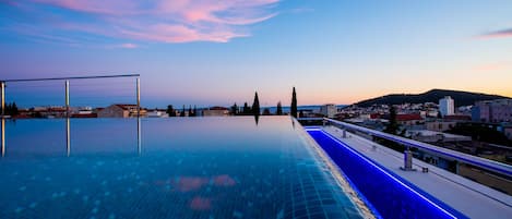 Una piscina al aire libre de temporada, sombrillas