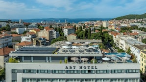 A hotel named ART HOTEL with a rooftop terrace featuring umbrellas and a view of the cityscape. - Art Hotel (Split)