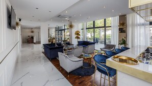 A spacious living area with modern furniture, a kitchen area, and large windows offering natural light. - Art Hotel (Split)