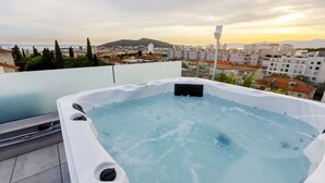 A rooftop hot tub with a cityscape view.