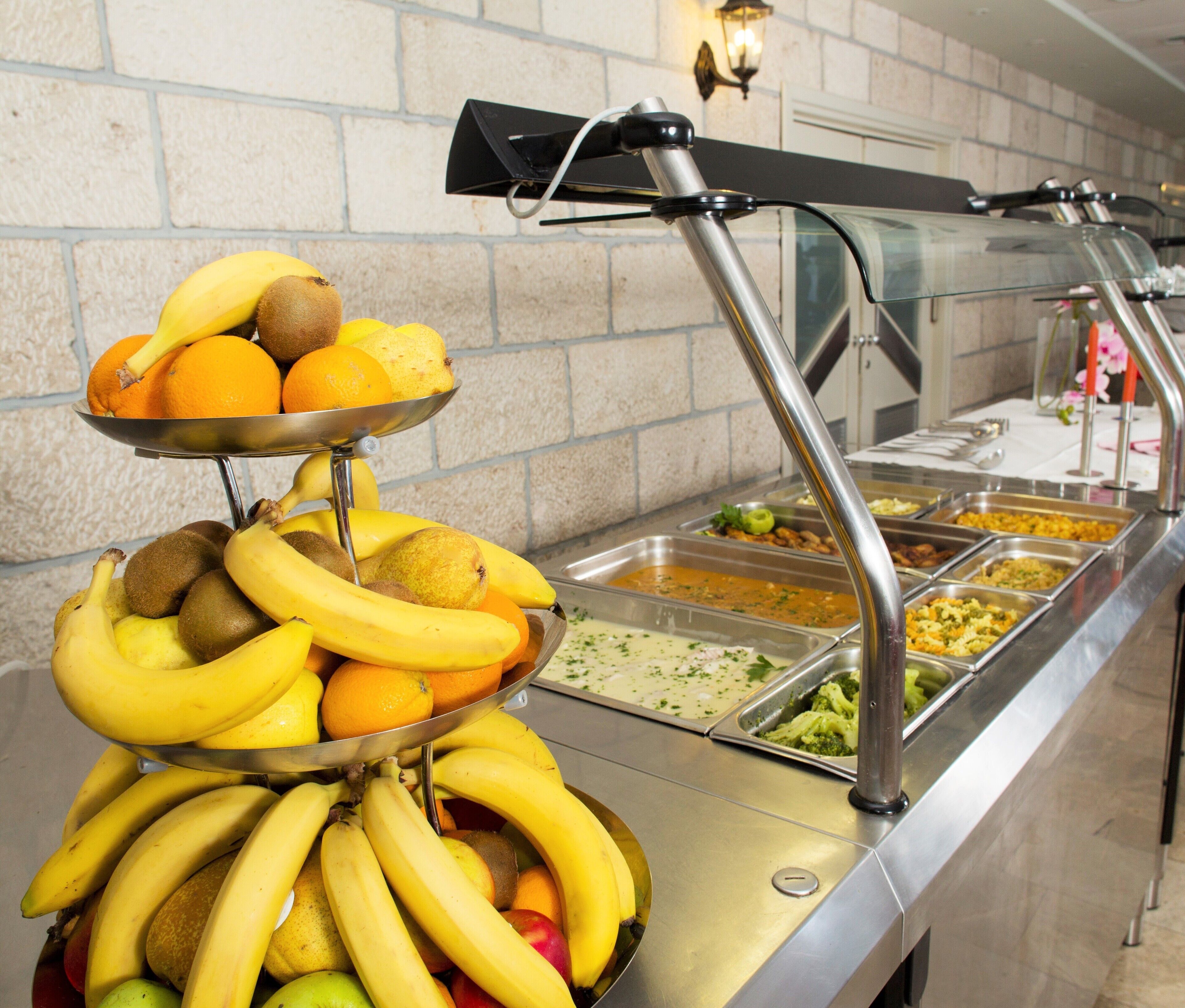 A buffet with a variety of fruits and food options.