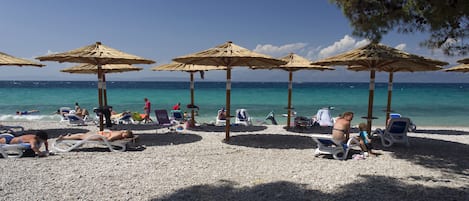 På stranden, solstolar och parasoller