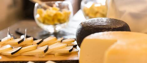 A cheese board with various types of cheese and a knife.