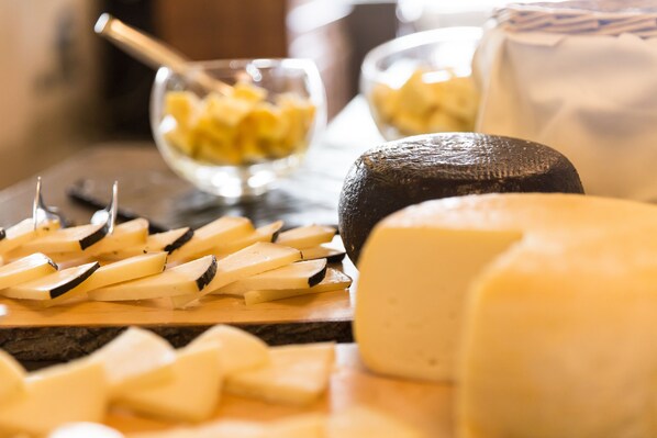 A cheese board with various types of cheese and a knife.