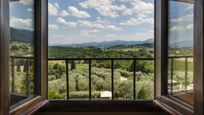 Une pièce dotée d’une grande fenêtre donnant sur un vignoble et des collines lointaines.