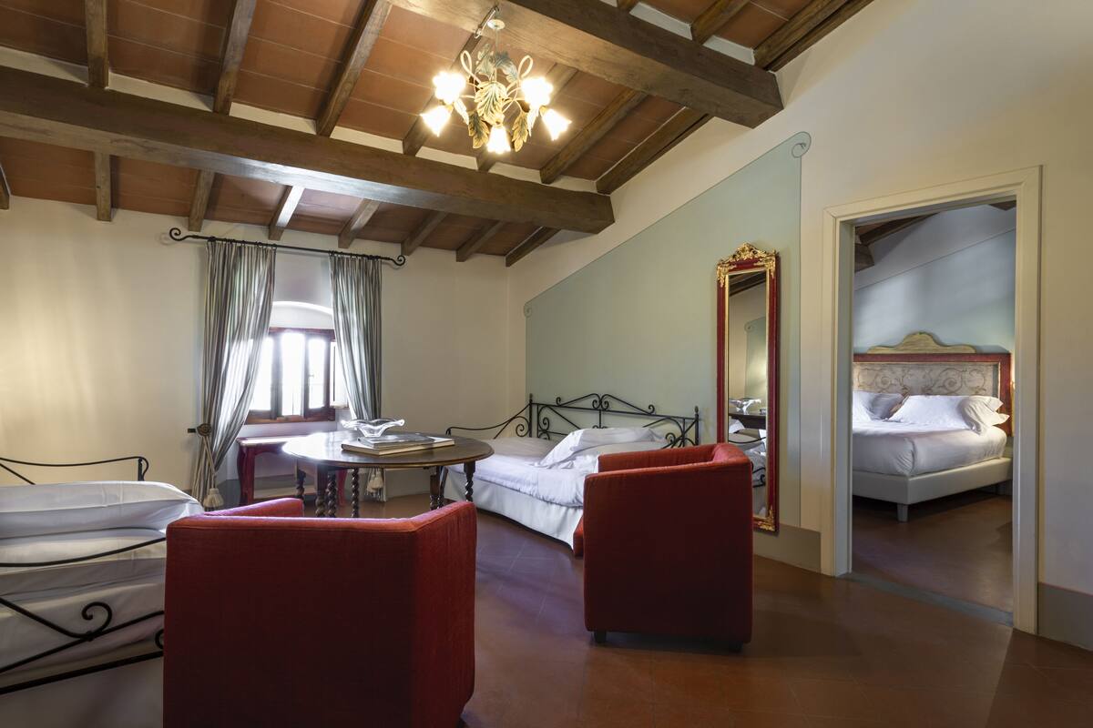 Une chambre à coucher avec un lit, une chaise, une table et un miroir.