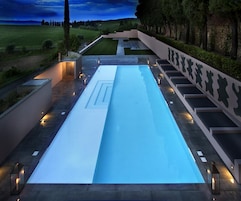 Una piscina al aire libre, sombrillas, sillones reclinables de piscina