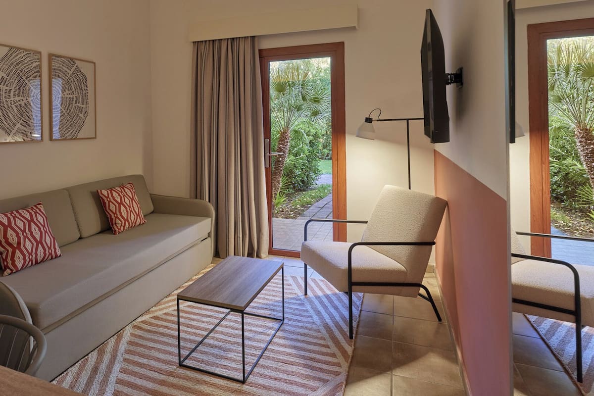 Suite estudio, vista al jardín | Edredón, caja de seguridad en la habitación y escritorio