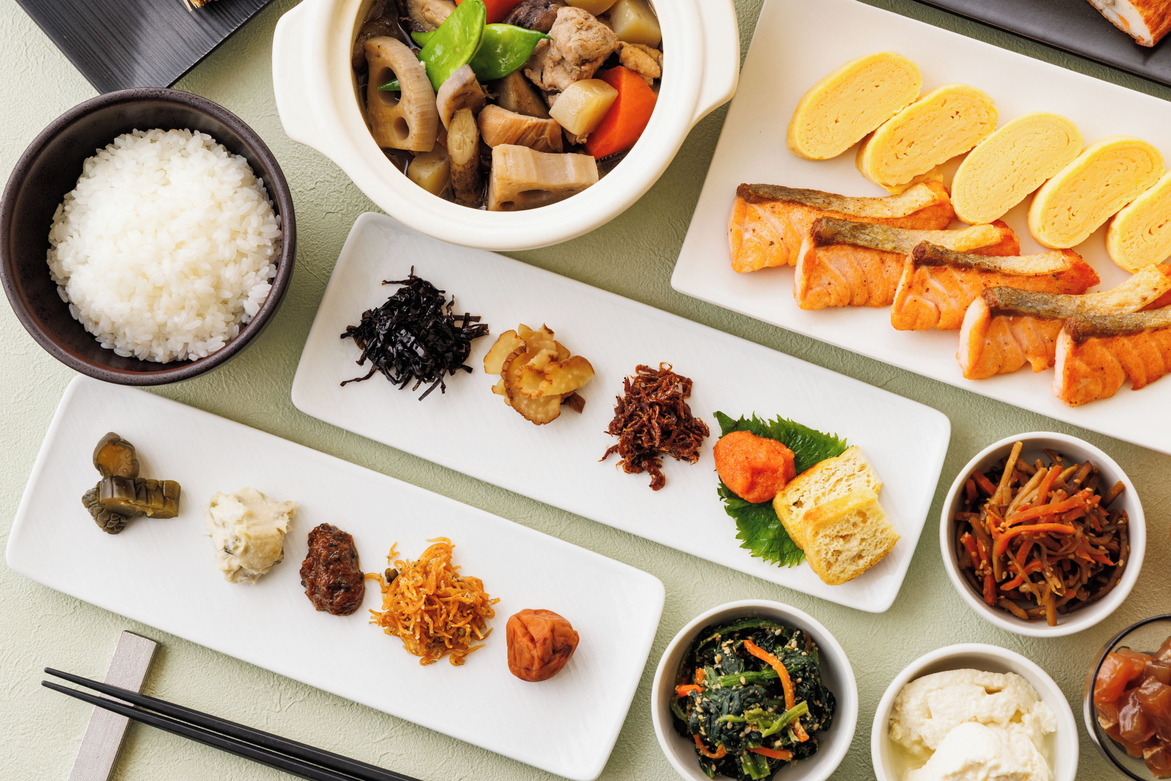 A variety of dishes including rice, seaweed, and different types of food arranged on a table.
