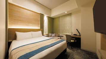 Habitación de hotel con una cama grande, un escritorio, una silla y una ventana.