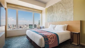 Habitación de hotel con una cama grande, vistas a la ciudad y un mapa en la pared.