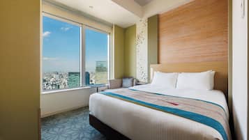 A hotel room with a large bed, a view of the city, and a cityscape through the window.