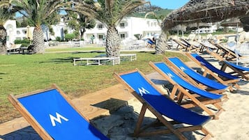 Nära stranden, solstolar och parasoller