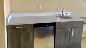 A kitchen with a built-in dishwasher, a sink, and a microwave.