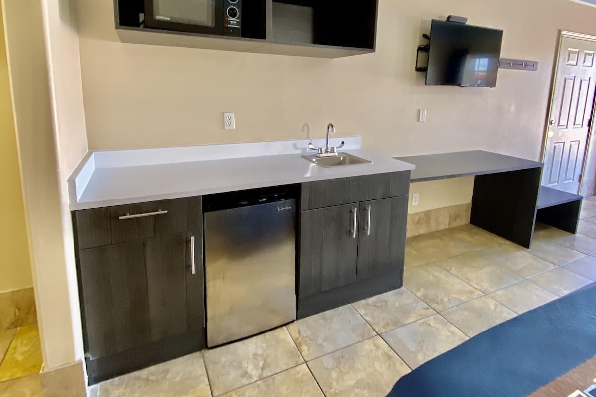 A modern kitchen with a built-in microwave, oven, and sink.