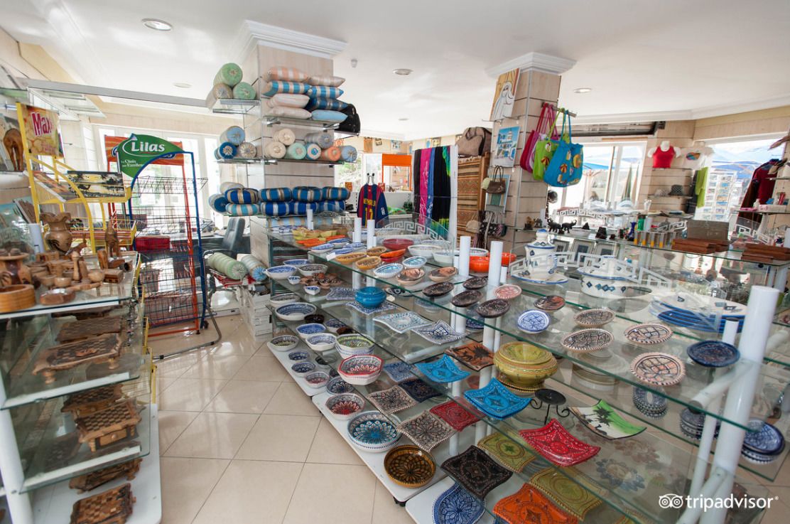 A store with glass display cases filled with colorful pottery and textiles.