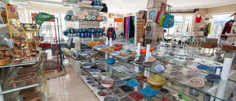 Una tienda con vitrinas repletas de cerámica y textiles coloridos.