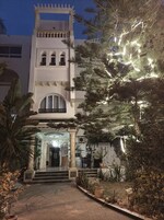 A building with a central entrance, columns, and a staircase leading up to the entrance.