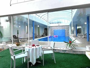 Una piscina al aire libre de temporada, sombrillas