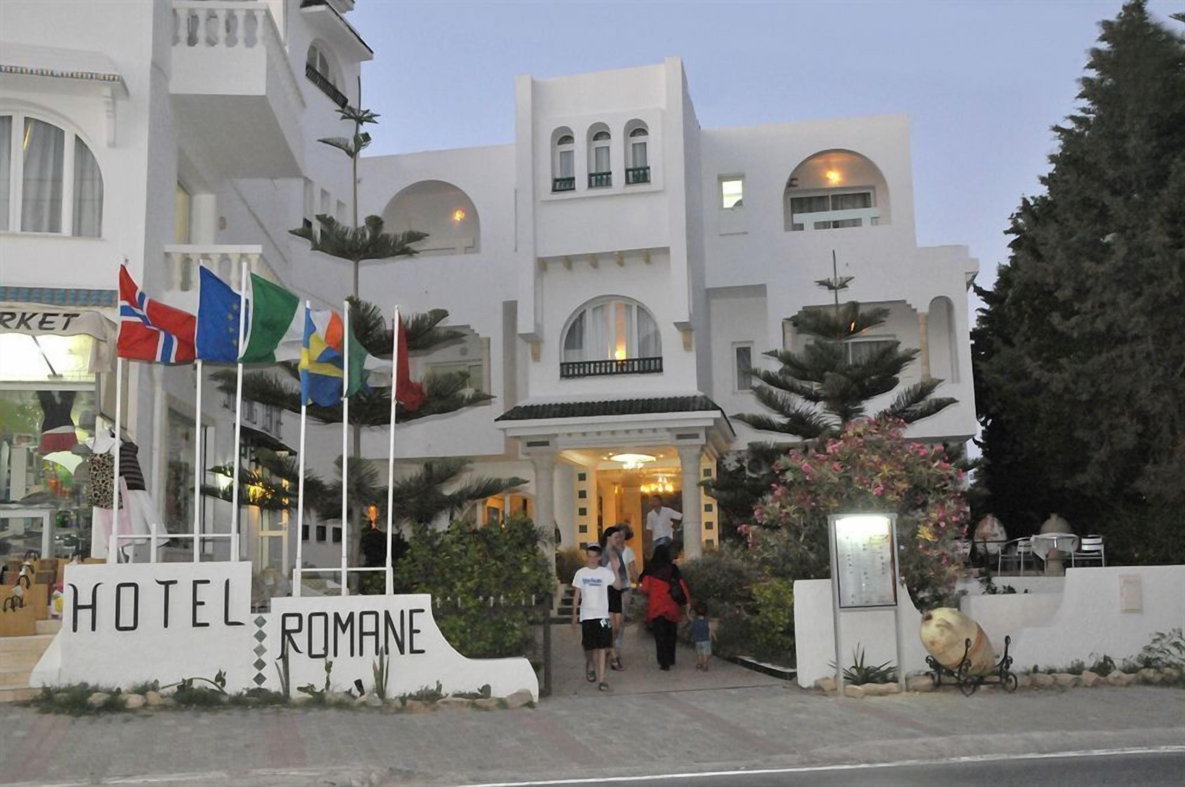 L'ingresso di un hotel con un cartello che riporta la scritta 'HOTEL ROMANE'.