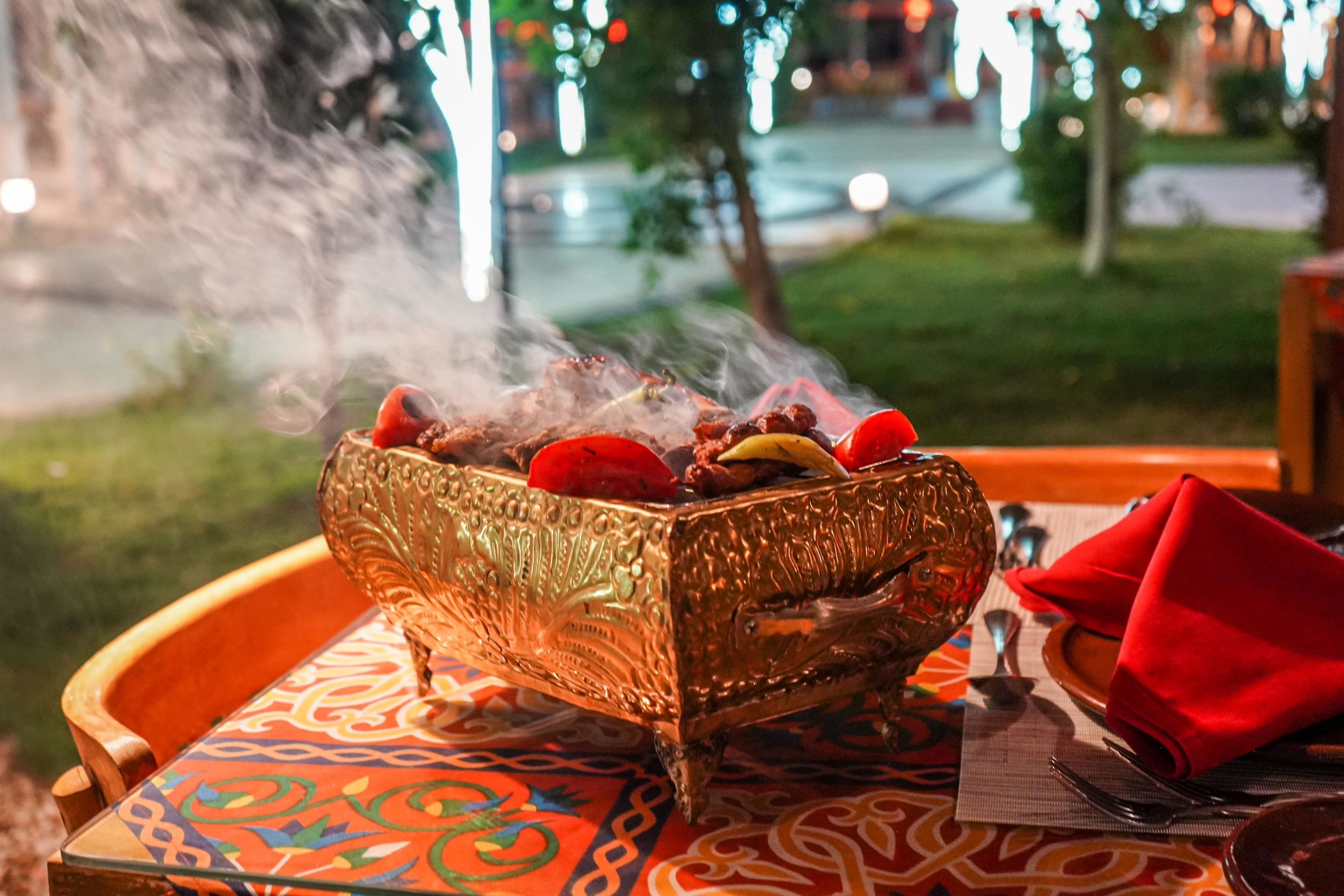 A table with a decorative bowl containing food, a red napkin, and a patterned tablecloth.