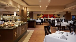 A buffet area with various food items and a dining section with tables and chairs. - Giftun Azur Resort - All inclusive (Hurghada)