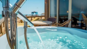 A hot tub with water flowing from a chrome faucet, surrounded by outdoor furniture and a large window. - JAZ Royal Palmariva (Makadi Bay)