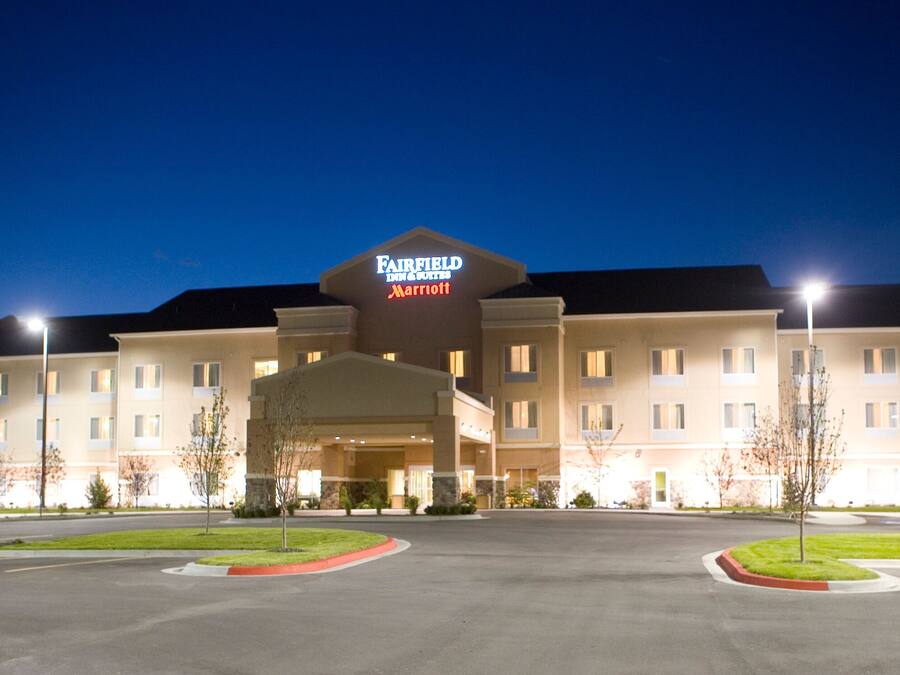 Ett Fairfield Inn & Suites by Marriott-hotell med en stor parkeringsplats och en väl upplyst entré.