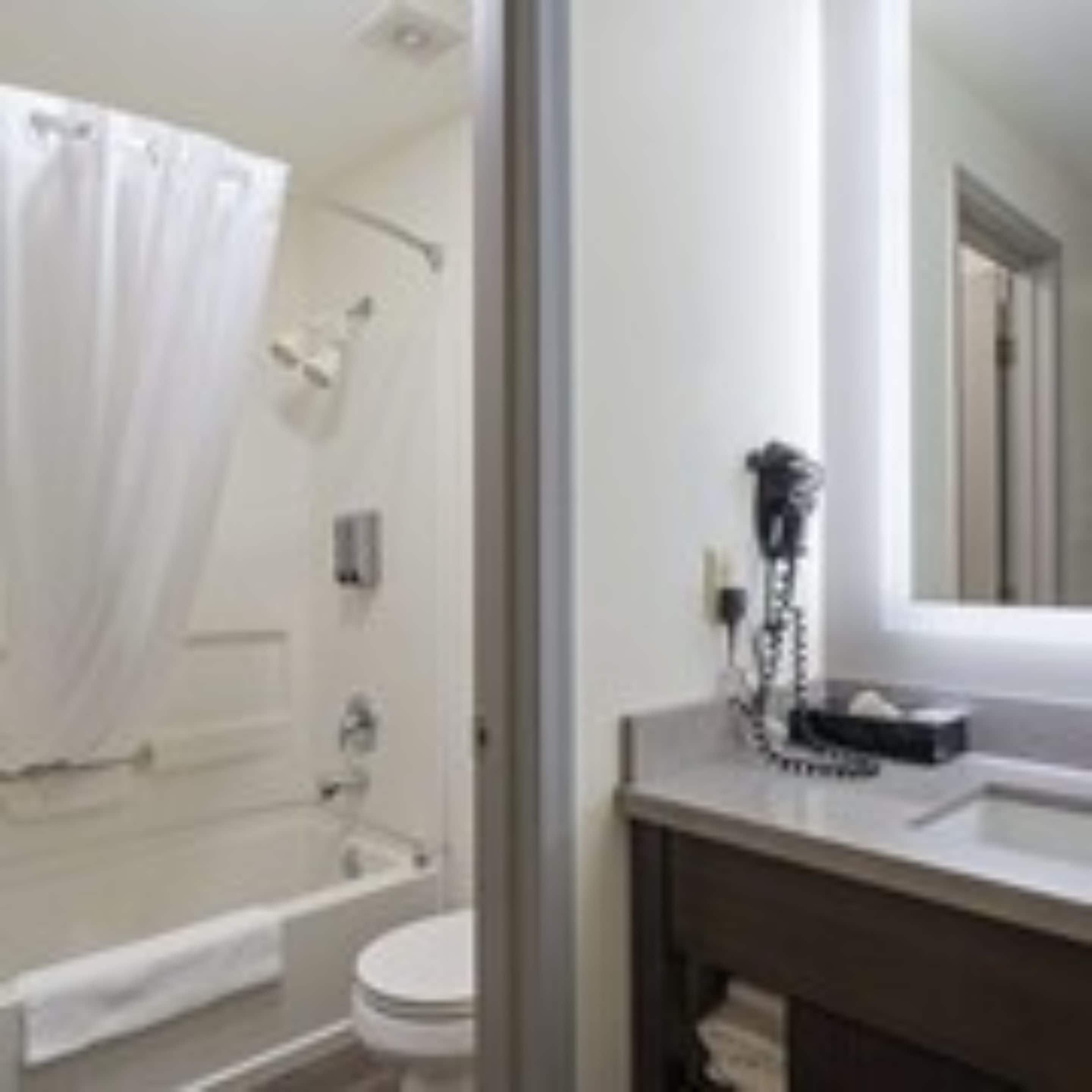 Une salle de bain équipée d’une baignoire, de toilettes et d’un meuble-lavabo avec un miroir.