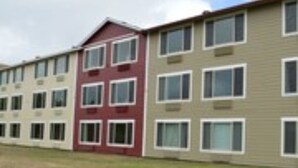 A row of multi-story buildings with a consistent architectural style, featuring rectangular windows and a flat roof.