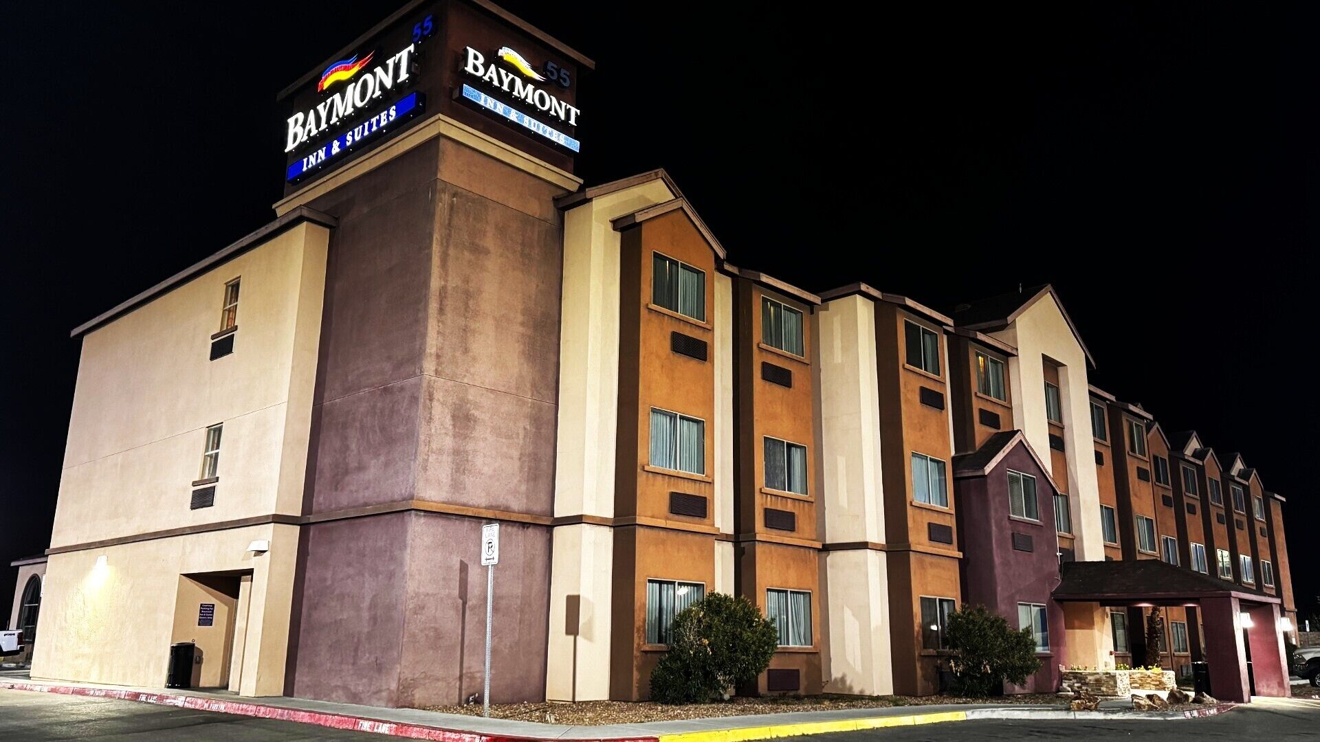 Un hotel de varios pisos con un llamativo letrero de 'Baymont', que indica que es un Baymont Inn & Suites.