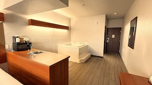 Habitación de hotel pequeña con mostrador de madera, lavabo y bañera.