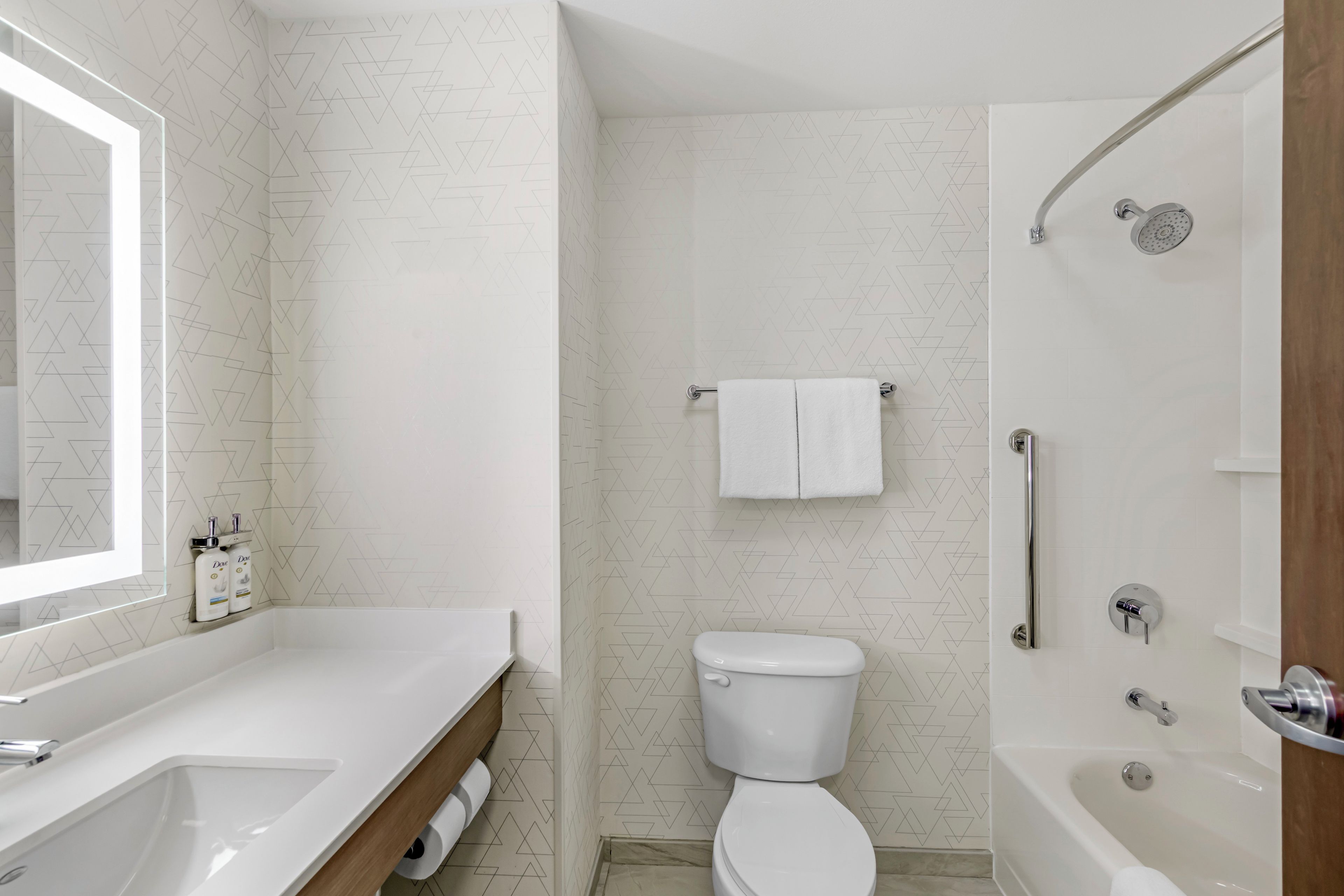 A modern bathroom with a white sink, toilet, and bathtub.