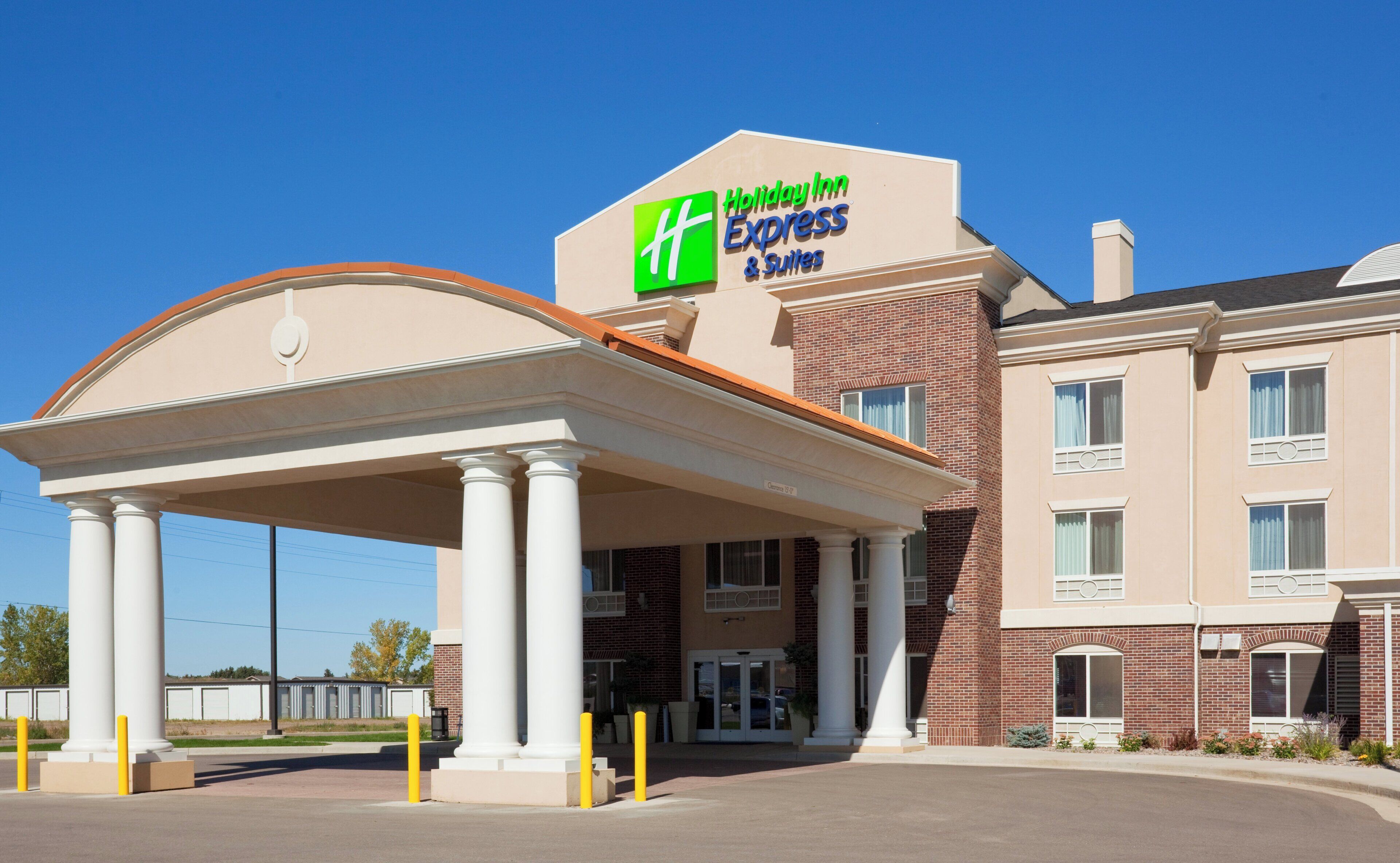 Um Holiday Inn Express & Suites com entrada coberta e fachada de tijolos.