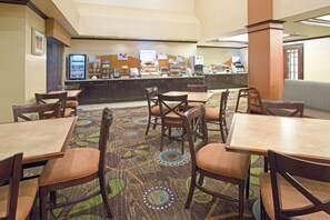 A hotel dining area with multiple tables and chairs, a buffet counter, and a coffee station. - Holiday Inn Express & Suites Minot by IHG (Minot)