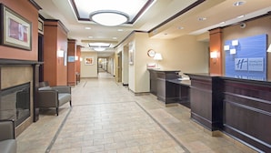 A hotel lobby with a reception desk, seating area, and a clock on the wall. - Holiday Inn Express & Suites Minot by IHG (Minot)